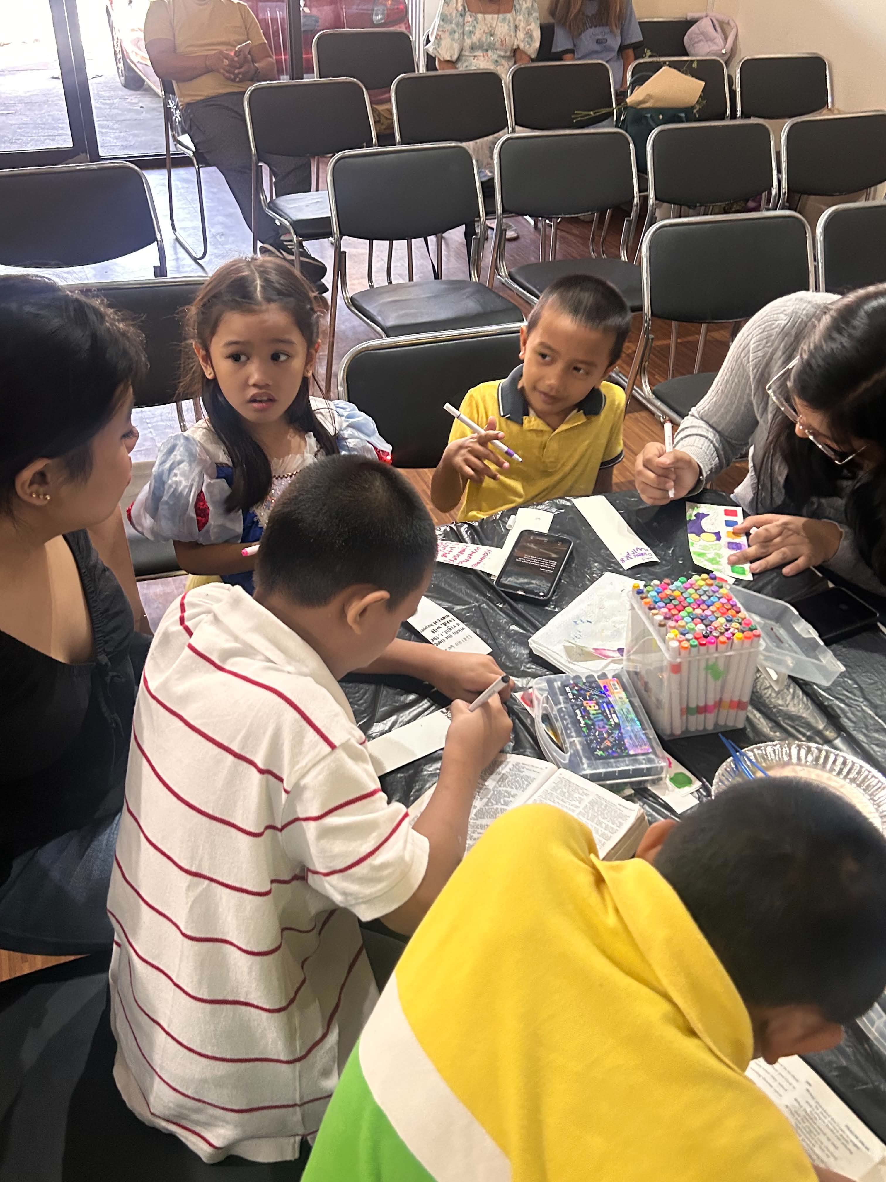 Kids and teens painting at the activity table